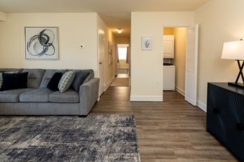 A living room with a grey couch and a rug. at Painters Mill Apartments, Owings Mills, 21117